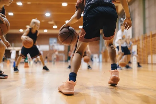 mehrere Personen spielen Basketball in einer Halle
